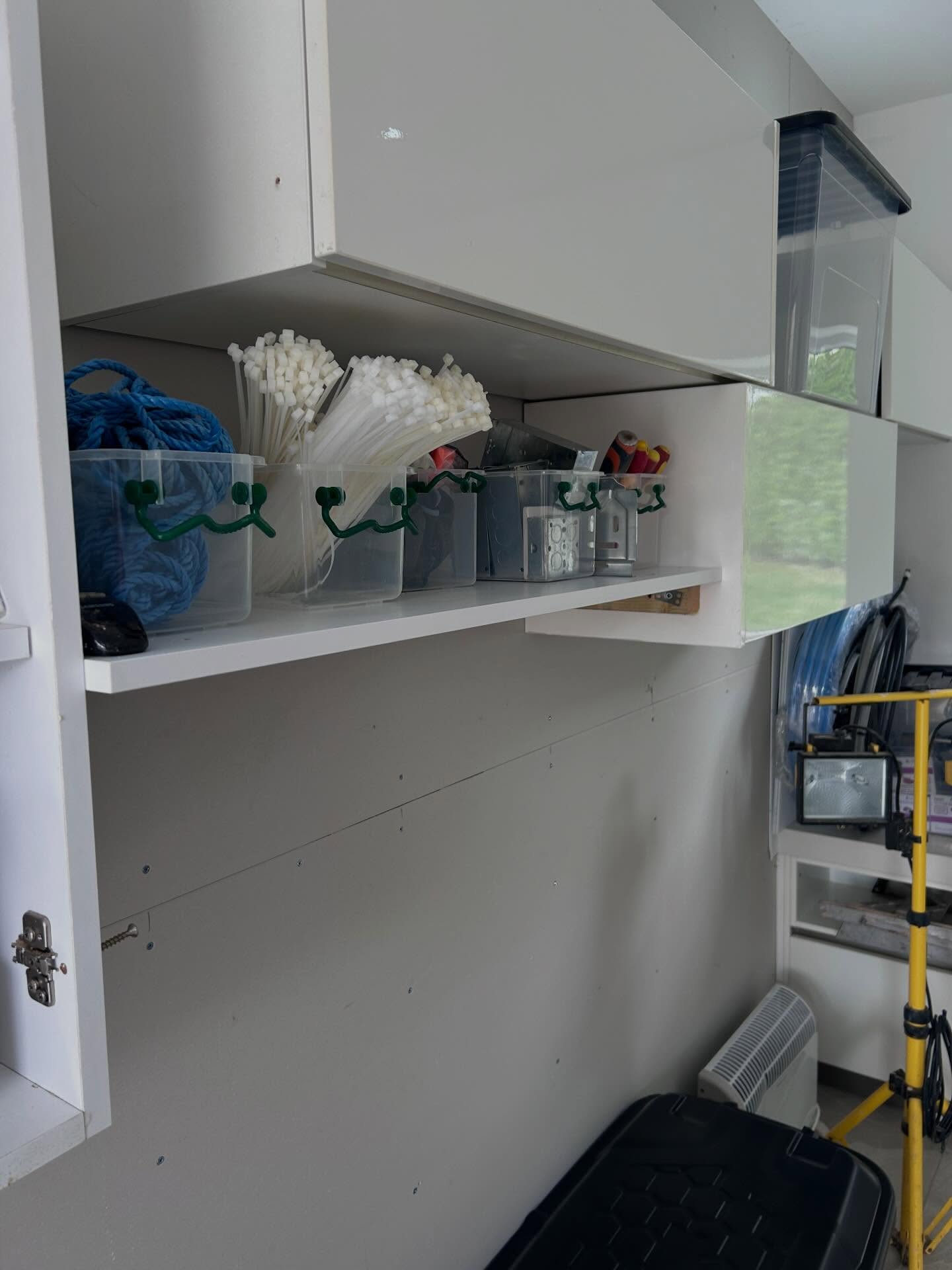 Clear storage bins with tools and supplies on the workshop bench